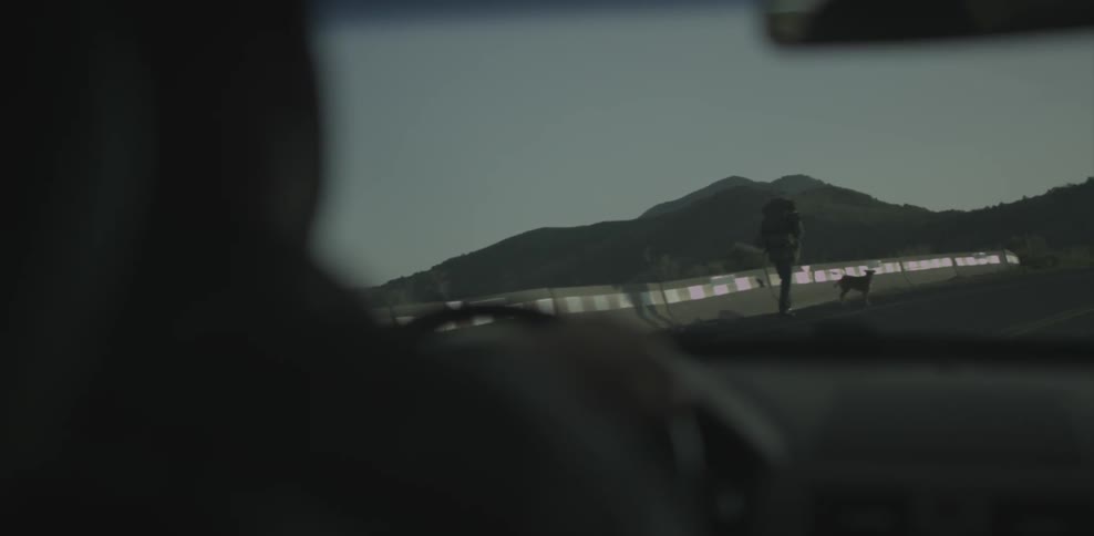 A man is driving a car around a winding road