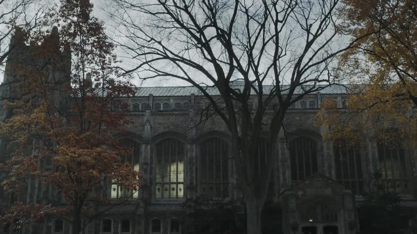 Man with a backpack walking towards a large building