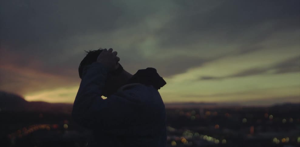 Silhouette of a man putting hands on his head looking down