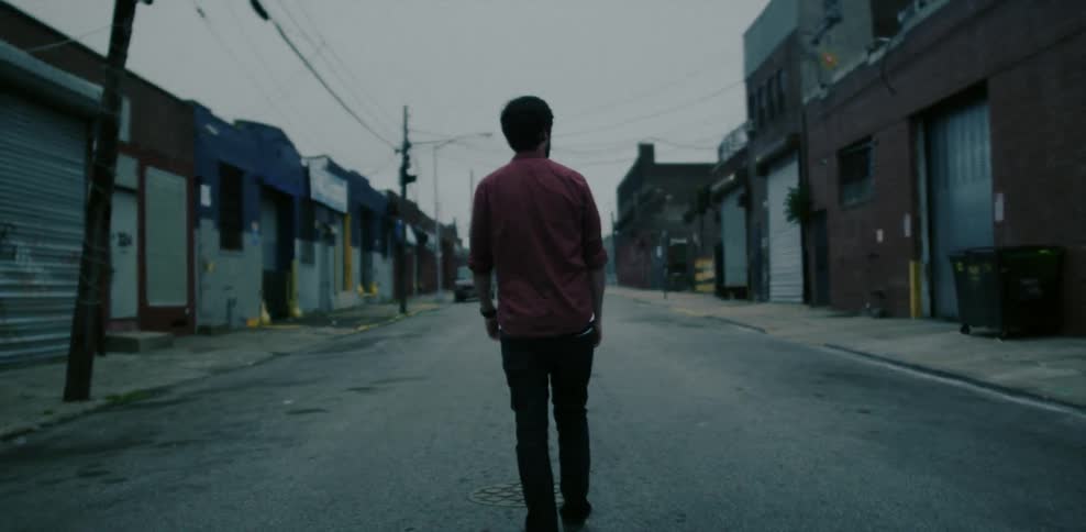 A man walks down a city alley