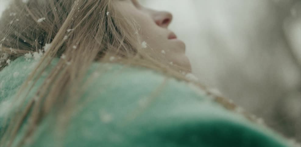 Close up of a woman's face with snow falling on it