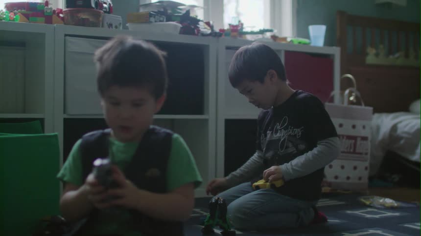 Two children play with toys in a bedroom