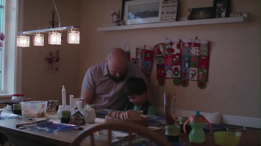 A man sits at a table with a boy