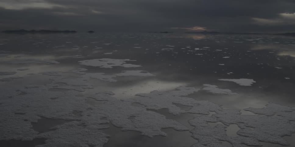 A body of water with thin patches of ice