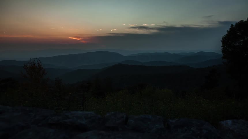 A sunset over several mountain ranges