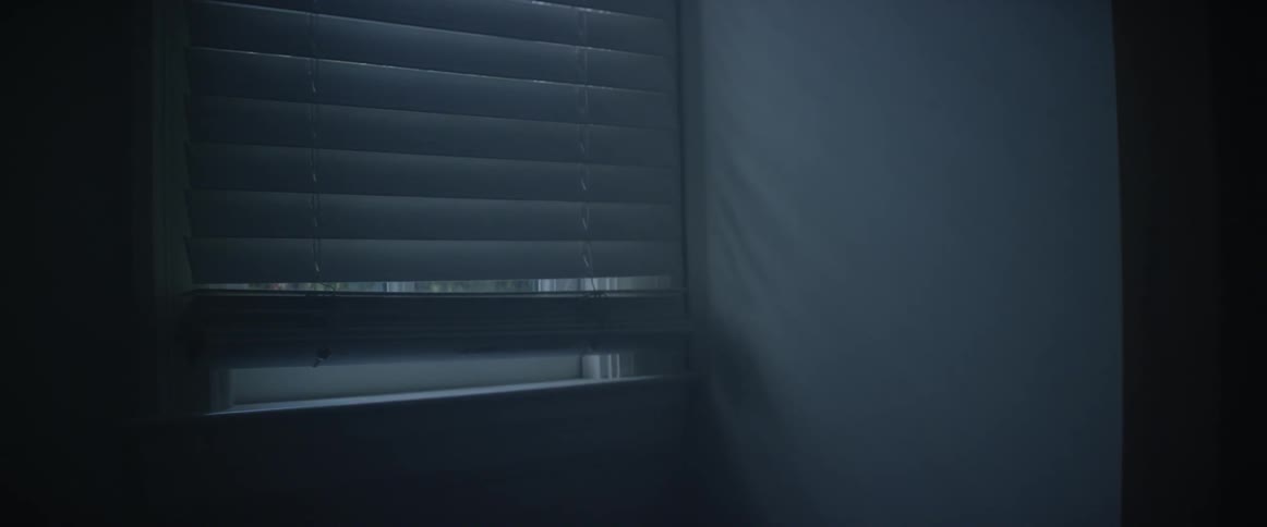 Dark room with the blinds mostly closed