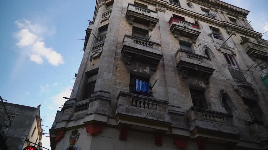 A stone apartment building towers overhead