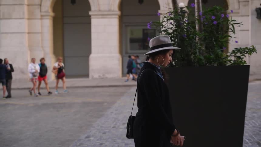 A woman walks down a sidewalk surrounded by pedestrians