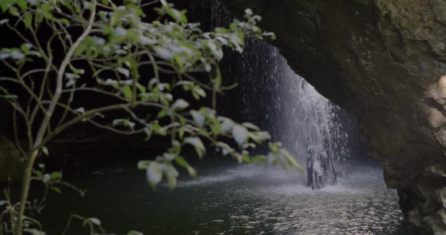 Water falls into a ravine from atop a mountain