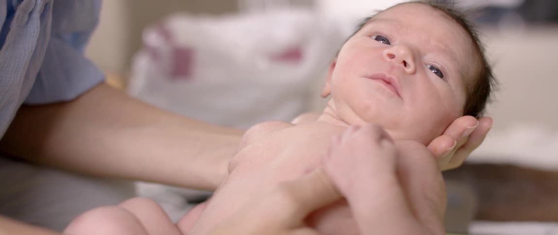 A baby is being held in a person's arms