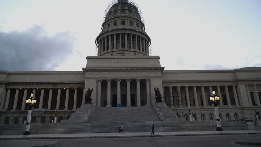 People walk in front of a capitol building
