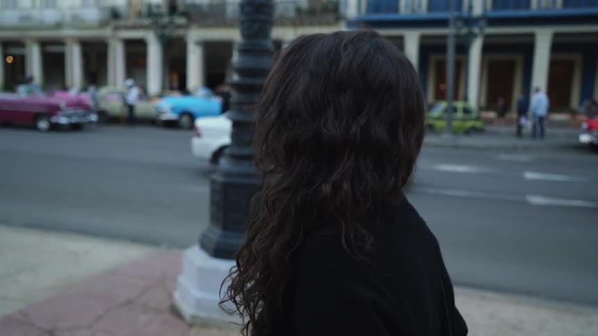 A woman walks on a city sidewalk