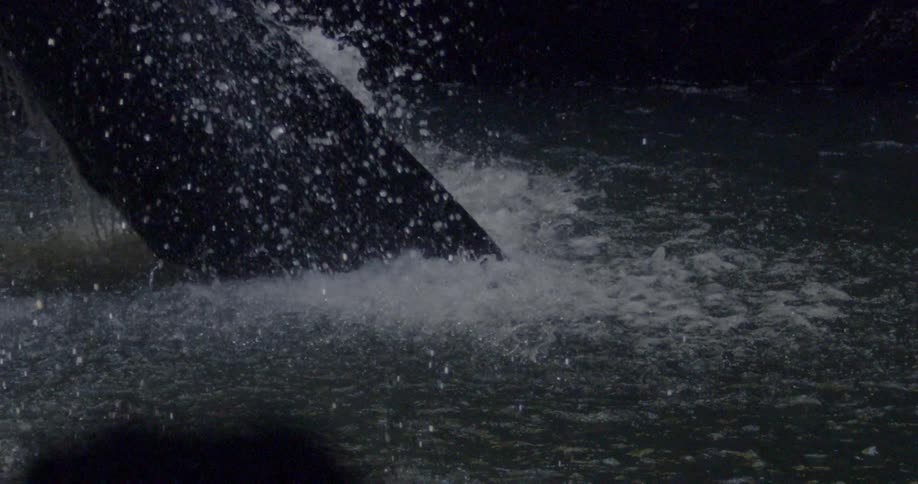 Water splashes down into the dark pond
