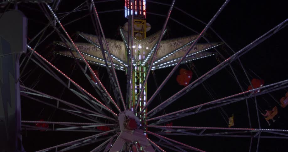 Amusement park rides spin and rotate in the night sky