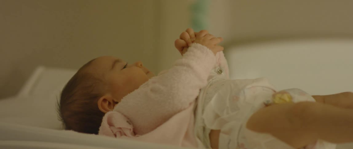 An infant lays down fidgeting