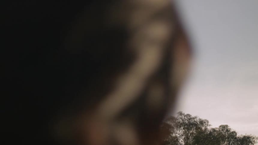 Woman watching a jet soar over trees