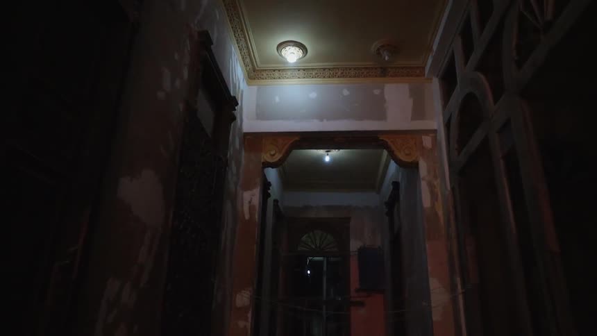 Ornate light fixtures hang above a dimly lit hallway