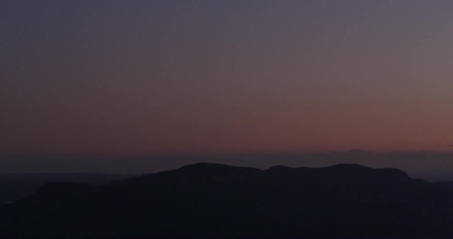 A mountain towers into the dusk sky