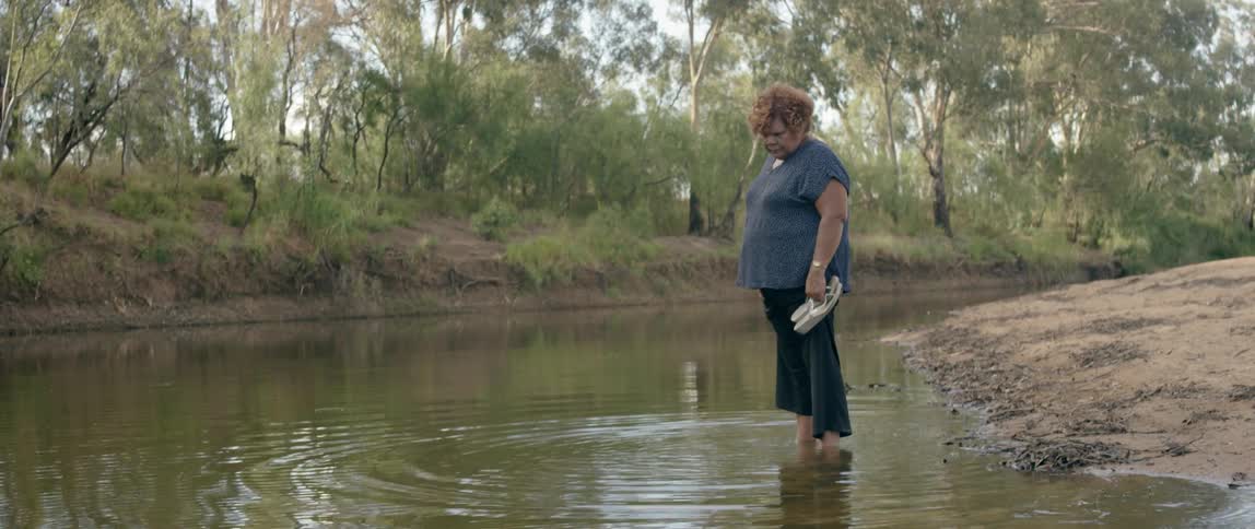 A woman kicks her bare feet in the water