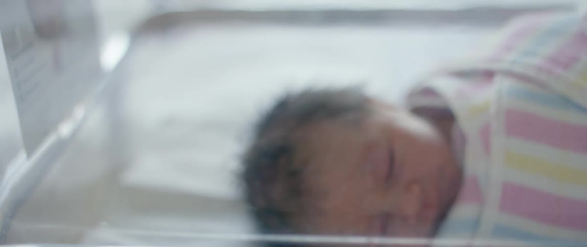 A baby is sleeping in the small crib