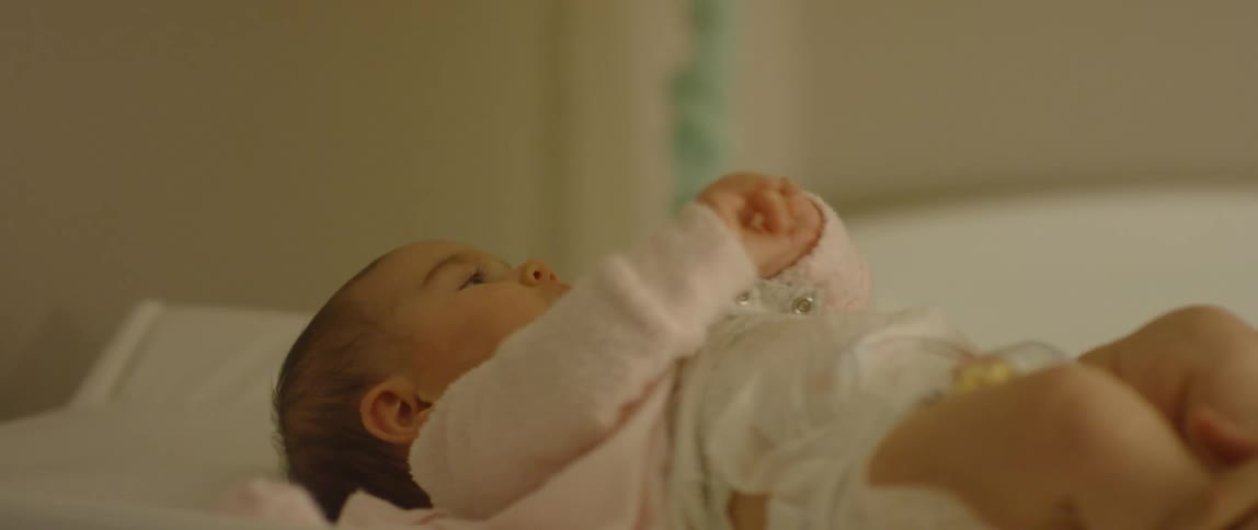 A person plays with a baby on a changing table