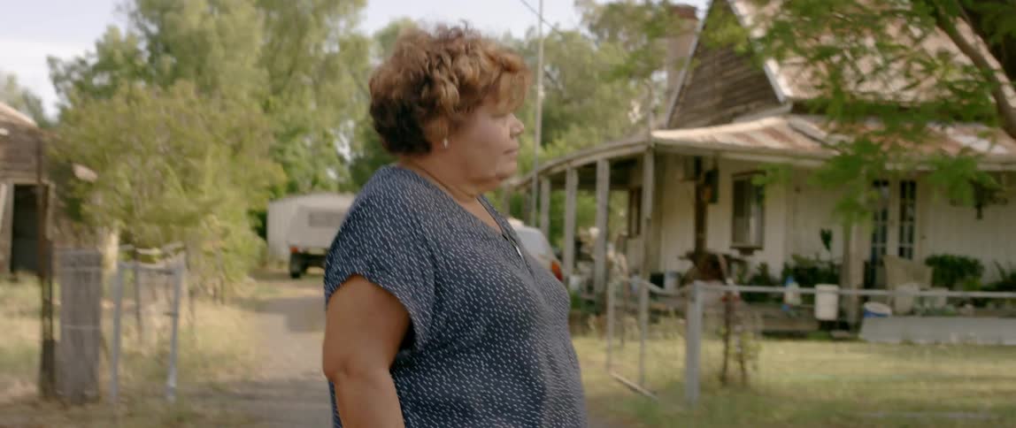A woman walks past homes and driveways in a neighborhood