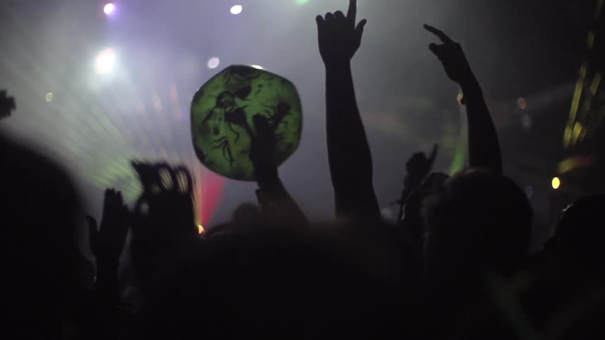 Crowd tosses a beach-ball at a light show