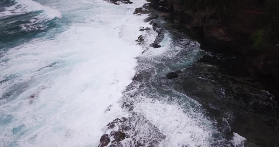 Ocean waves wash ashore a rocky beach