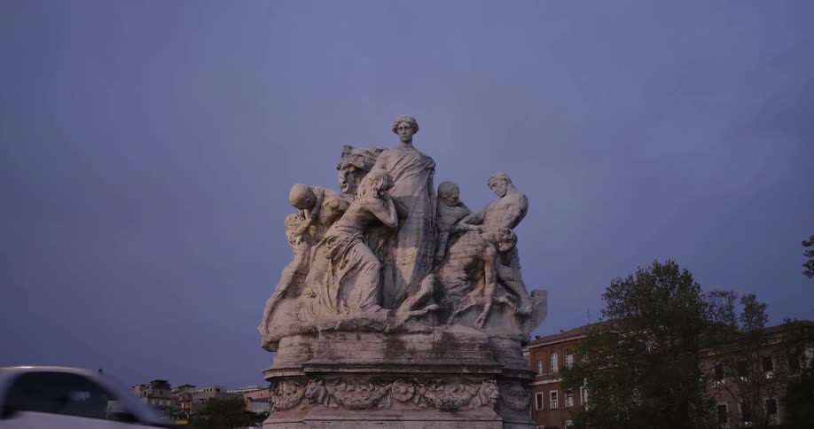 A statute of people in a city as cars drive by