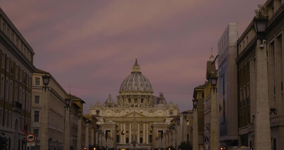 A domed city building is shown at sunset