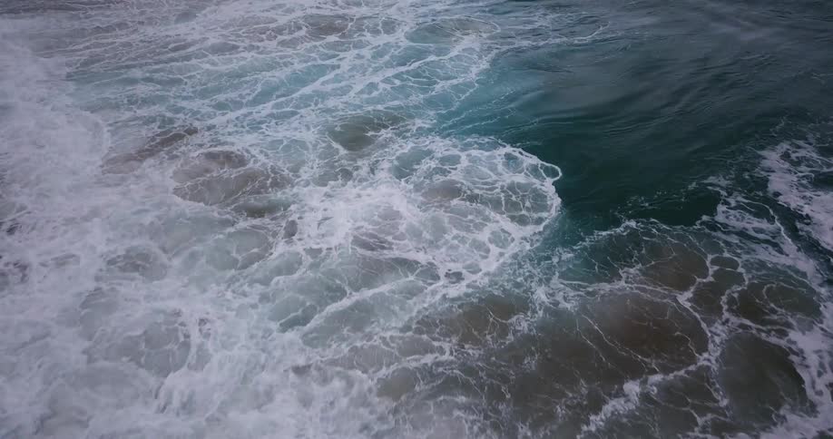 Waves break and foam as they come to shore