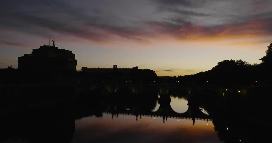 A bridge and the sunset sky are reflected in the water