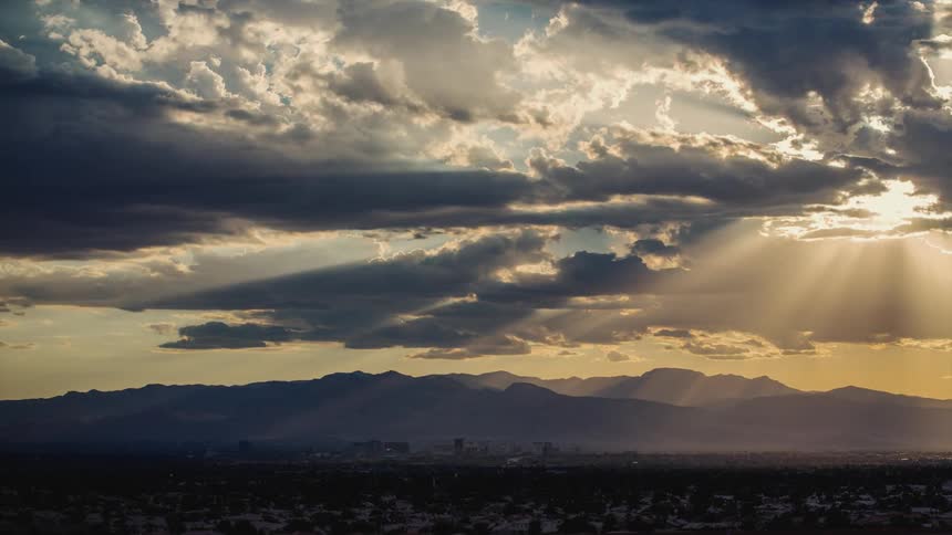 Sun rays stream through storm clouds at dawn