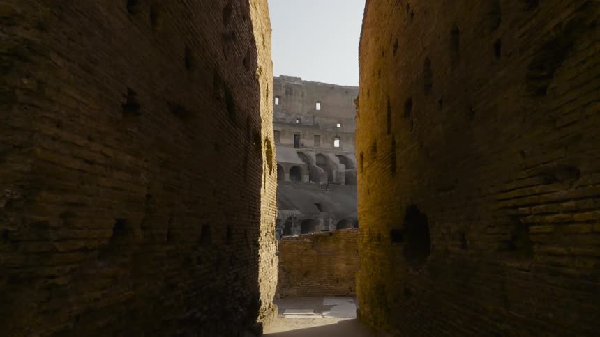 Stone walls and walkway lead to the interior of the colosseum