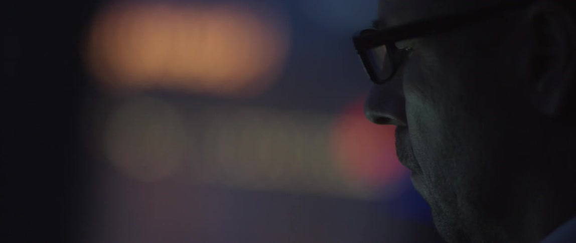 Man staring with lights in the background