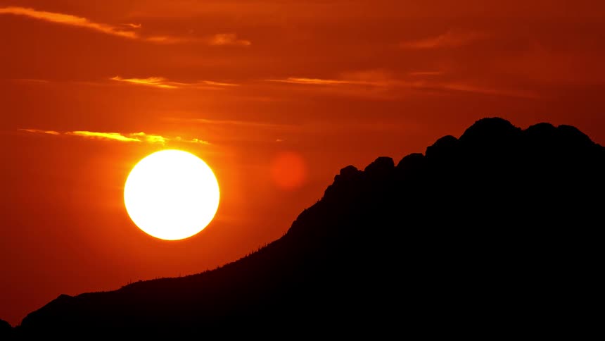 The sun is setting behind the mountain