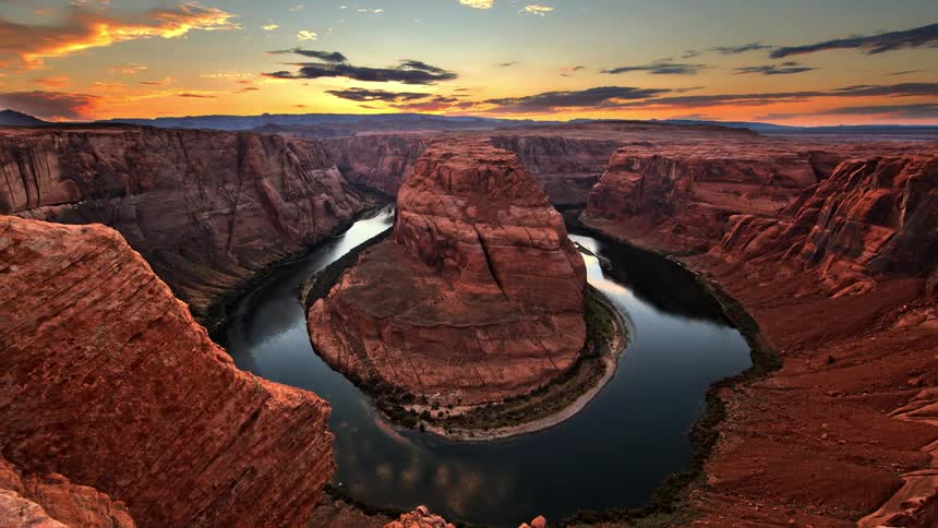 A river runs through a rocky canyon at sunset