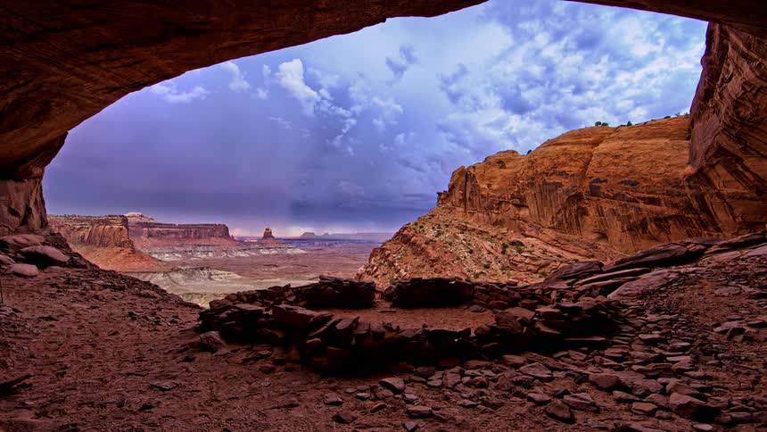 Lightning striking and clouds passing through a rocky desert