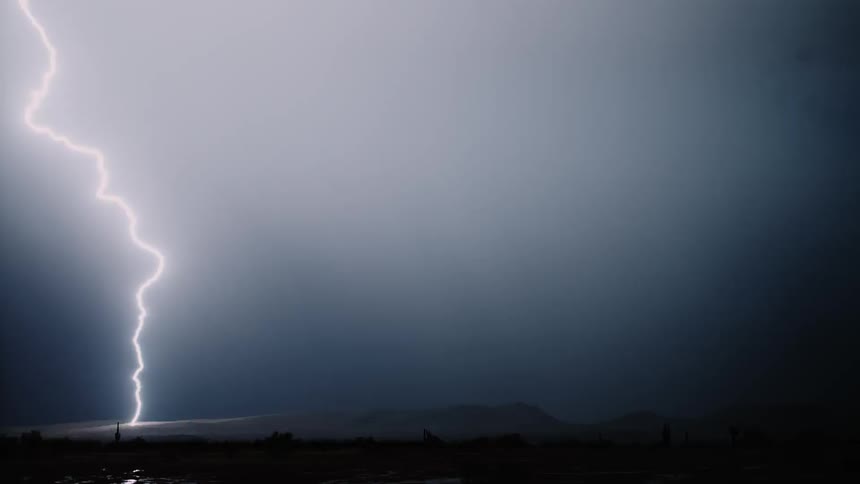 The night time sky has a storm with lightning and rain