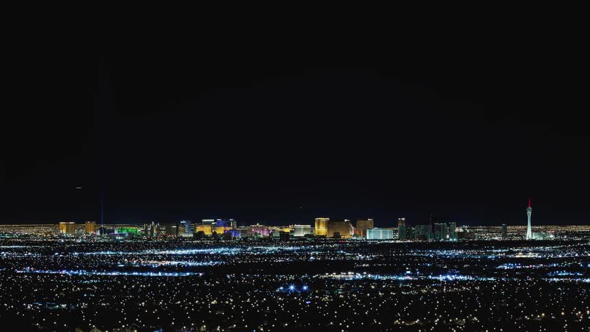 City buildings light the dark night sky