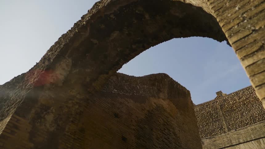 Sunlight shines down on an old stone structure