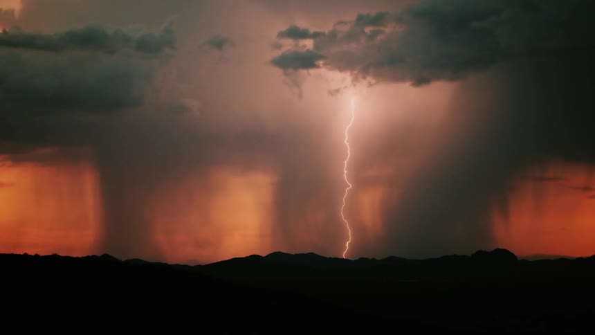 Lightning snakes down from the sky at sunset