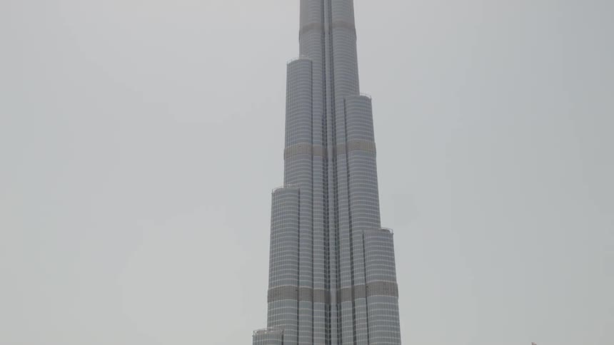 A very tall building goes into the cloudy sky