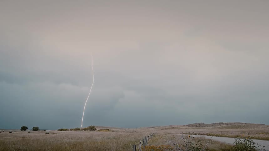 Storm clouds float over a rural field