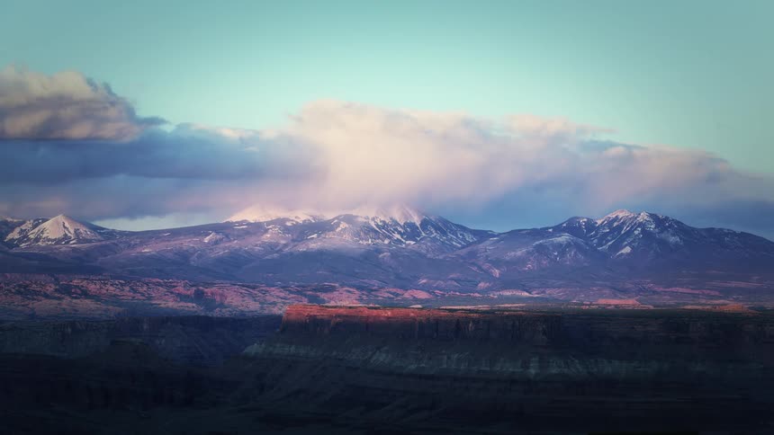 Clouds pass over mountains and a canyon