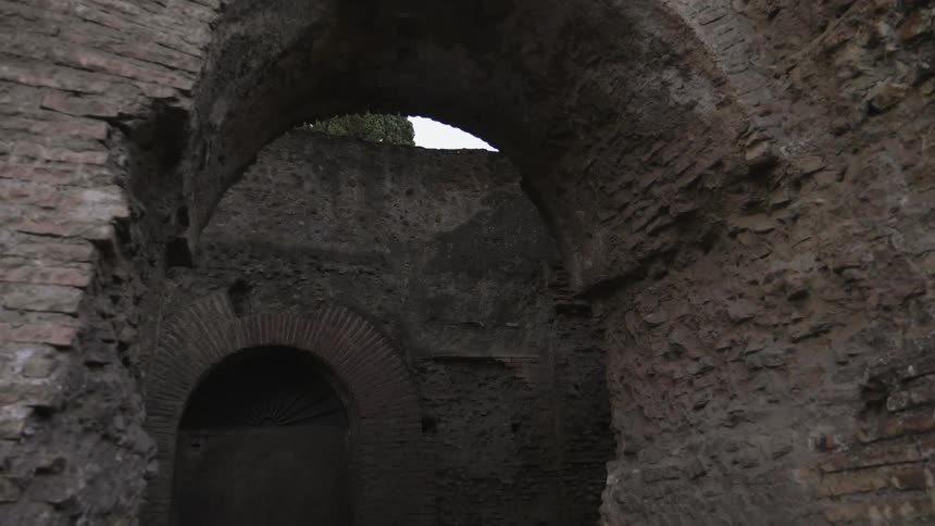 The broken down building has a large archway