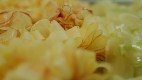 Piles of shaved vegetables sit on a table