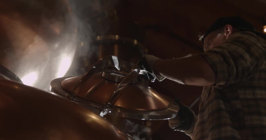A man slowly closes a still lid