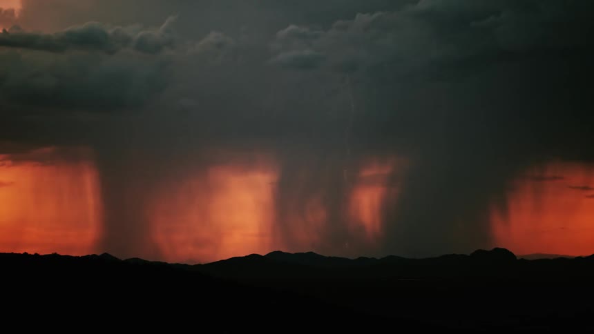 Storm clouds produce lightning and rain at dusk
