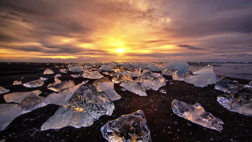 The shore is lined with many blocks of ice